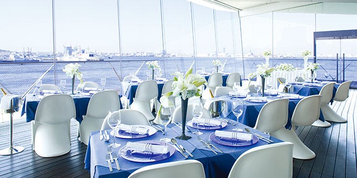 白と青を基調としたさわやかな店内にテーブル席が数席設けられ、窓の外には青い海が広がっている。