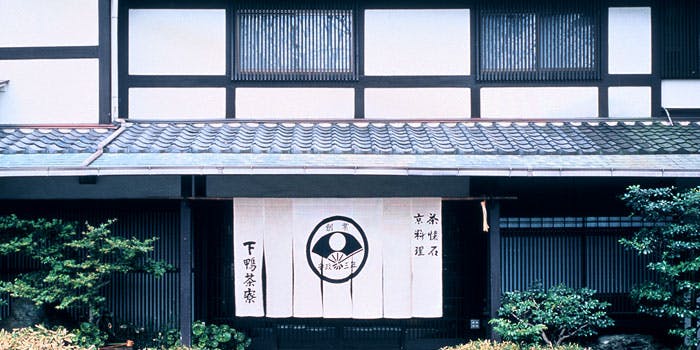 重厚感漂う日本家屋の入口に、店名の入った白いのれんが掲げられている。
