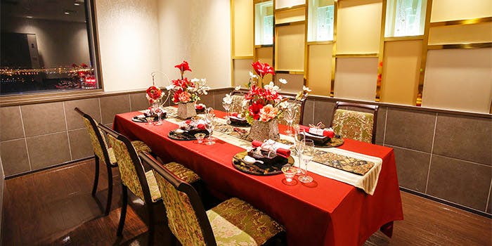 白地に金をアクセントカラーにした豪華な個室に、赤いクロスがかかった6人がけのテーブル席が設置されている。