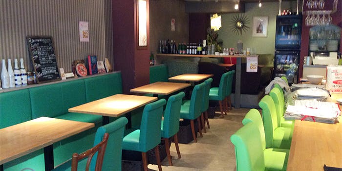 緑の椅子と木目テーブルの店内、ターナ フォルノ